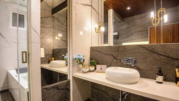 A modern bathroom with marble walls, a double sink vanity, and a large mirror.