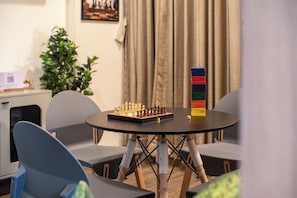 A chessboard on a round table with chairs around it. - ELIVAAS signature Eulophia 3BHK Villa (Varsoli)