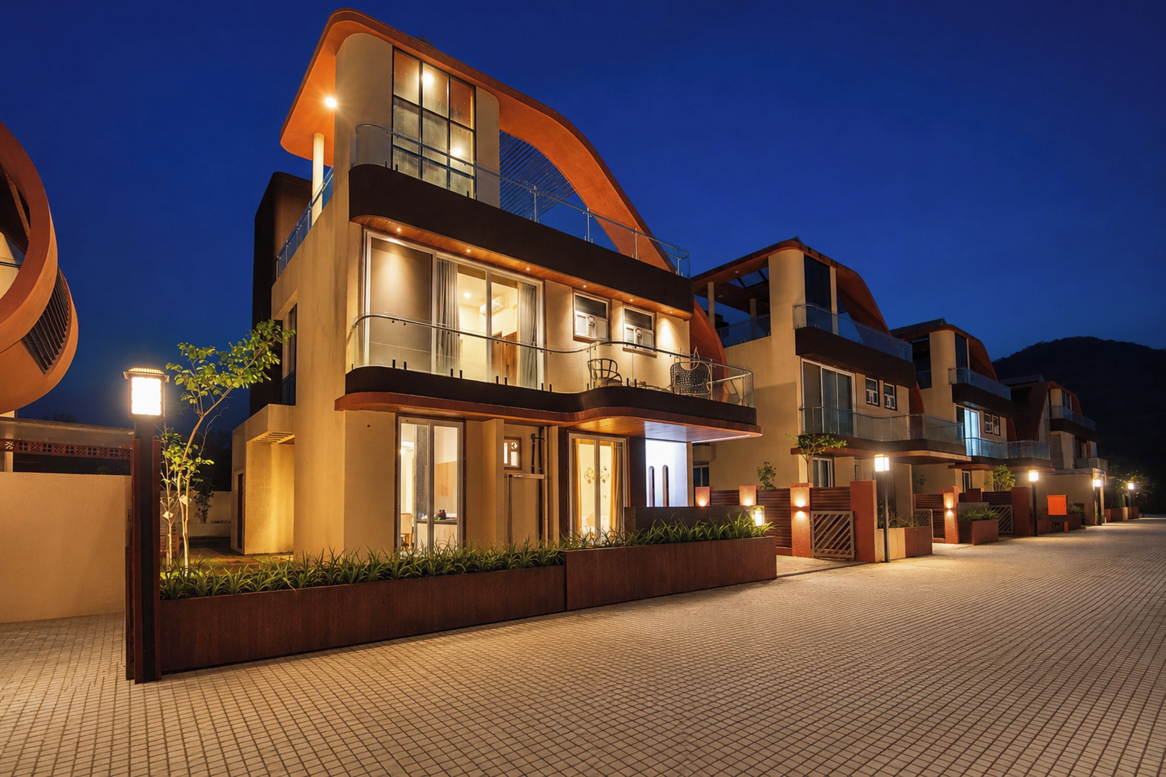 Un edificio residencial moderno de varios pisos, con un llamativo elemento arquitectónico curvo, ventanas amplias y una entrada bien iluminada.