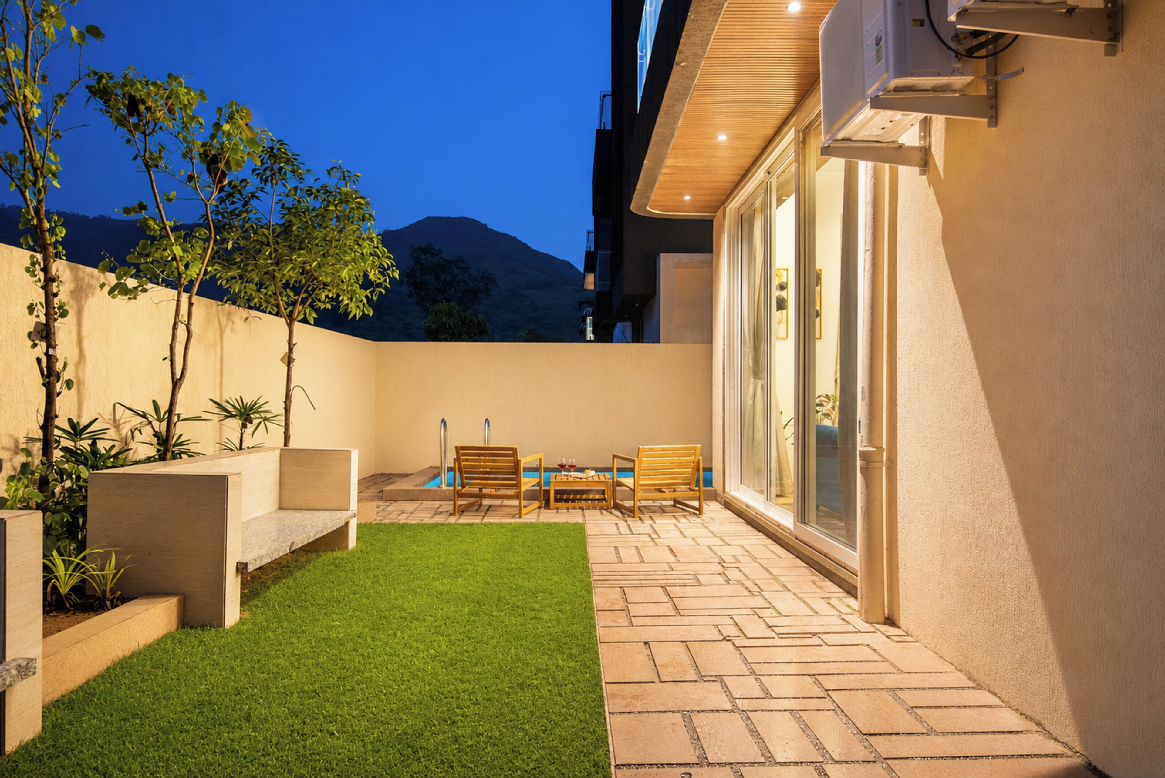 A patio with a small pool, outdoor seating, and a view of a mountain.