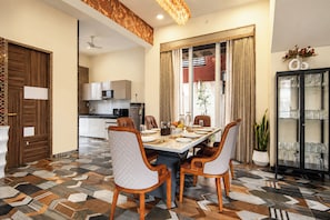 Een eethoek met een tafel voor vier personen, omringd door stoelen met een bekleedde rugleuning.