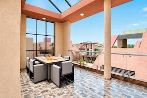 A rooftop terrace with a dining table and chairs, a view of the cityscape, and a tiled floor. - ELIVAAS signature Eulophia 3BHK Villa (Varsoli)