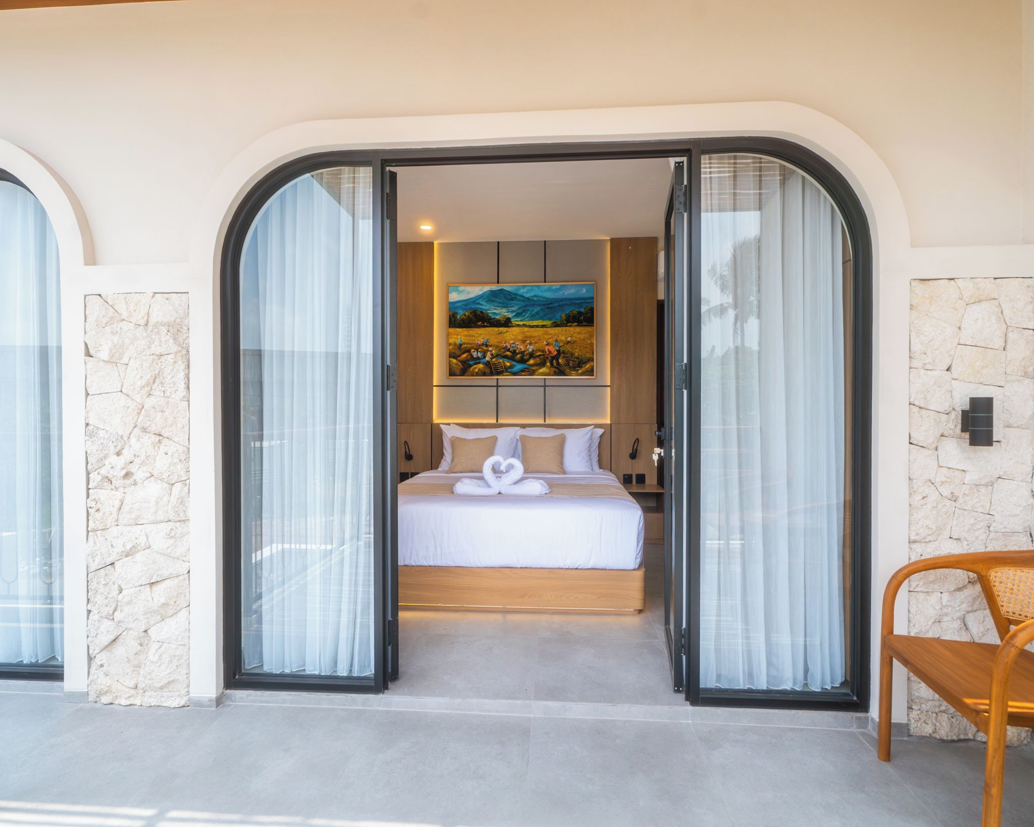 Una habitación de hotel con cama, un cuadro y una pared de piedra.