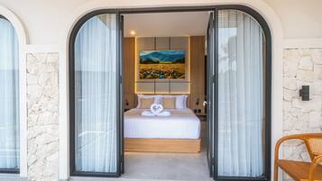 Una habitación de hotel con cama, un cuadro y una pared de piedra.