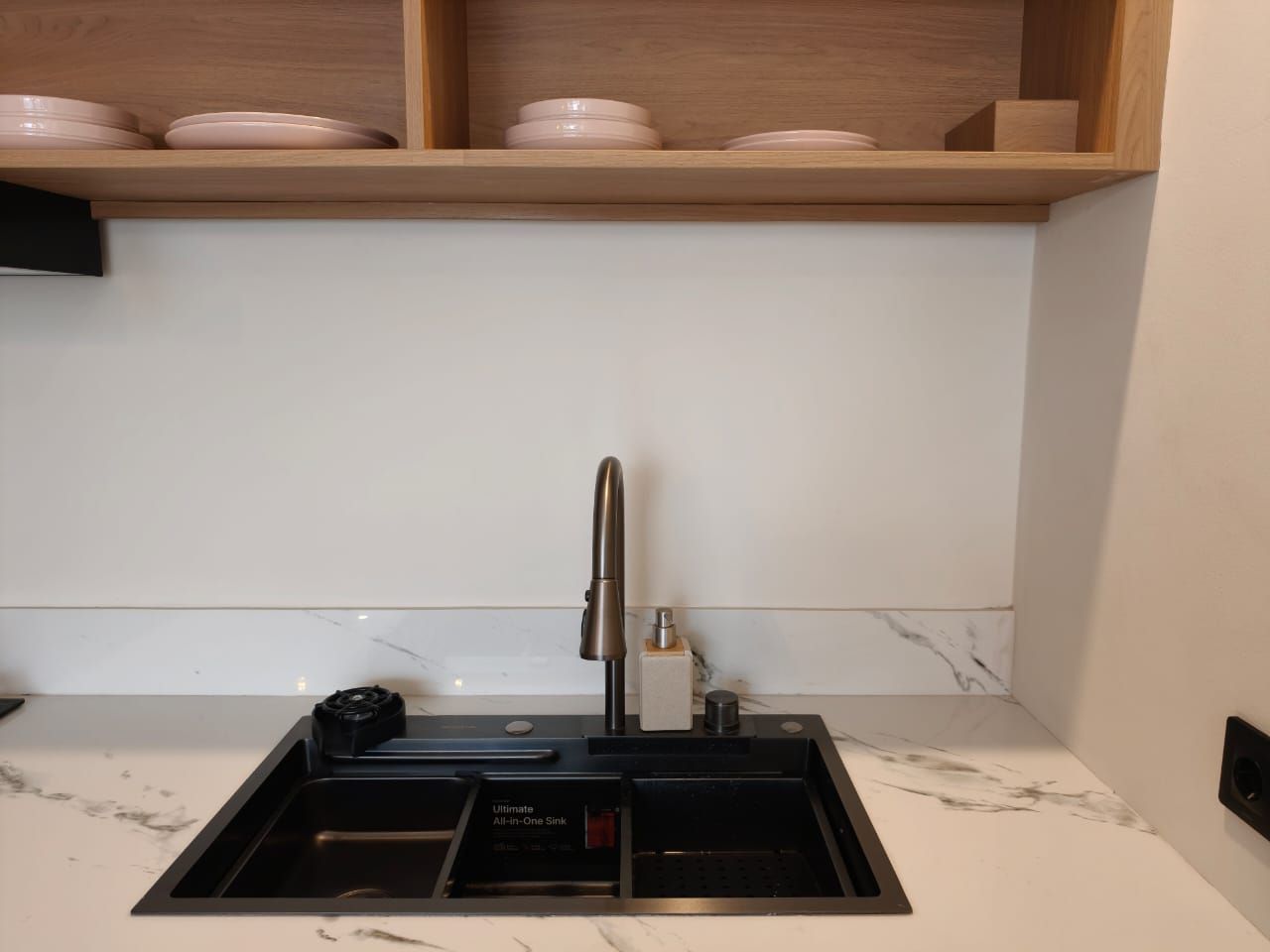 Una cucina con lavello incassato, rubinetto e dispenser per sapone.
