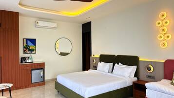 A hotel room with a bed, bedside tables, a desk with a chair, a round mirror, and a ceiling fan.
