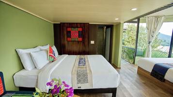 A hotel room with a large bed, a smaller bed, and a balcony with a view.