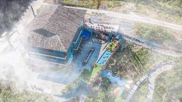 A building with a tiled roof, a swimming pool, and a water slide.
