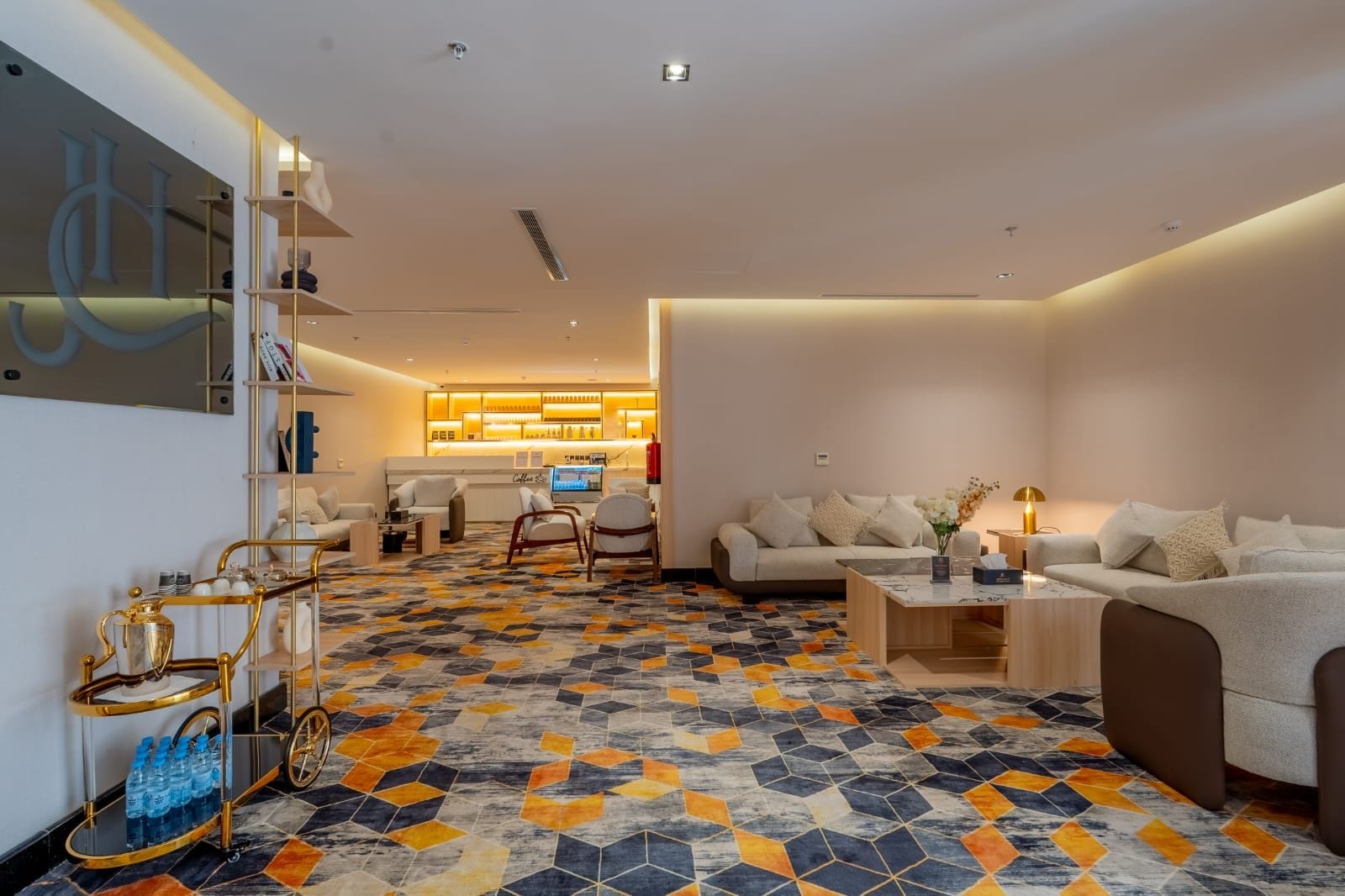 Una sala moderna con un sofá, sillones, una mesa de centro y un suelo estampado.