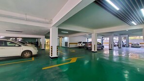 A multi-level parking garage with several cars parked, clear directional arrows on the floor, and a clean, well-lit environment. - Himalaya Heights View Palace Apartment (Nairobi)