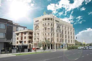 Un hotel de estilo arquitectónico tradicional, con varios balcones y una entrada destacada.