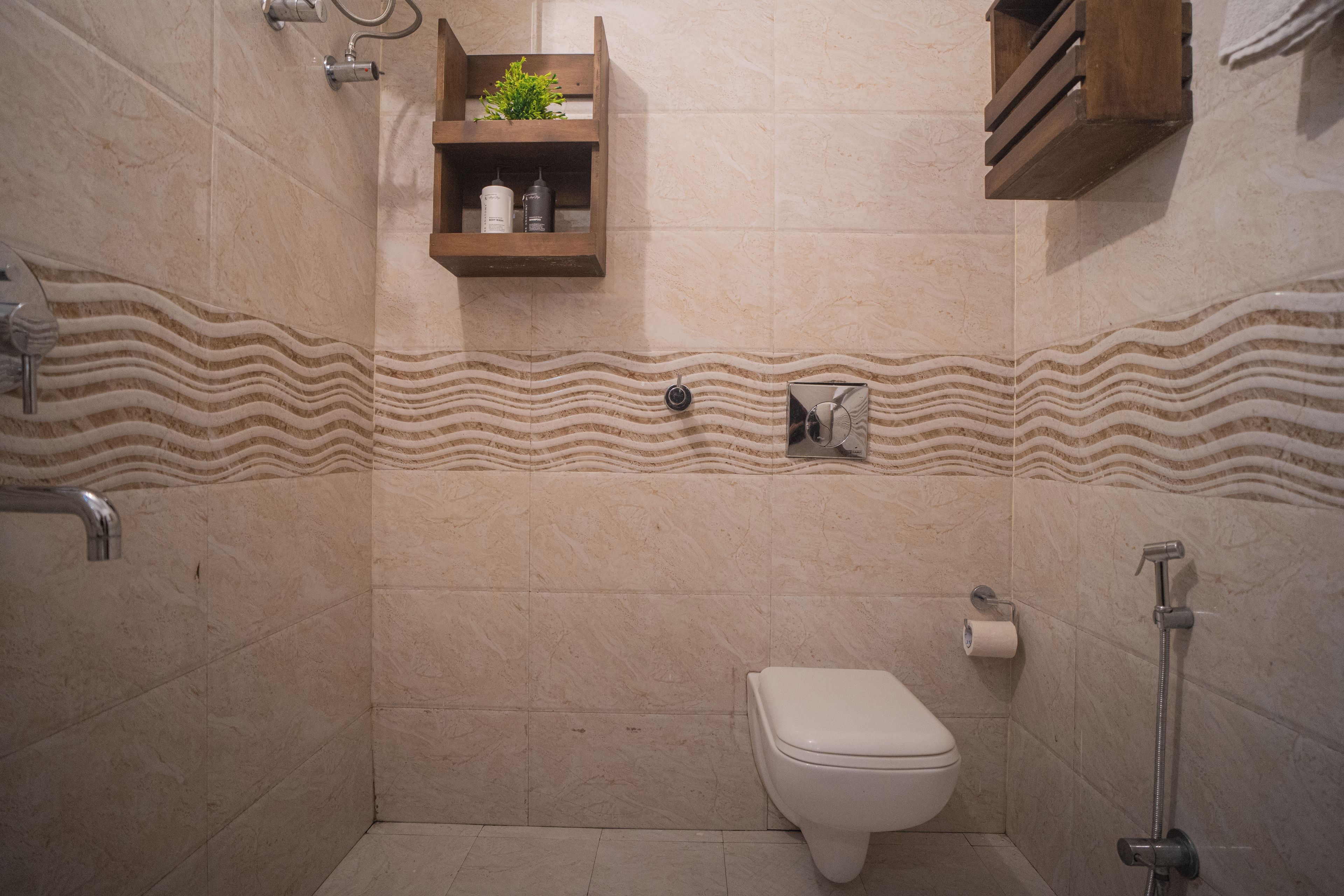 A bathroom with a toilet, shower, and shelf with toiletries.