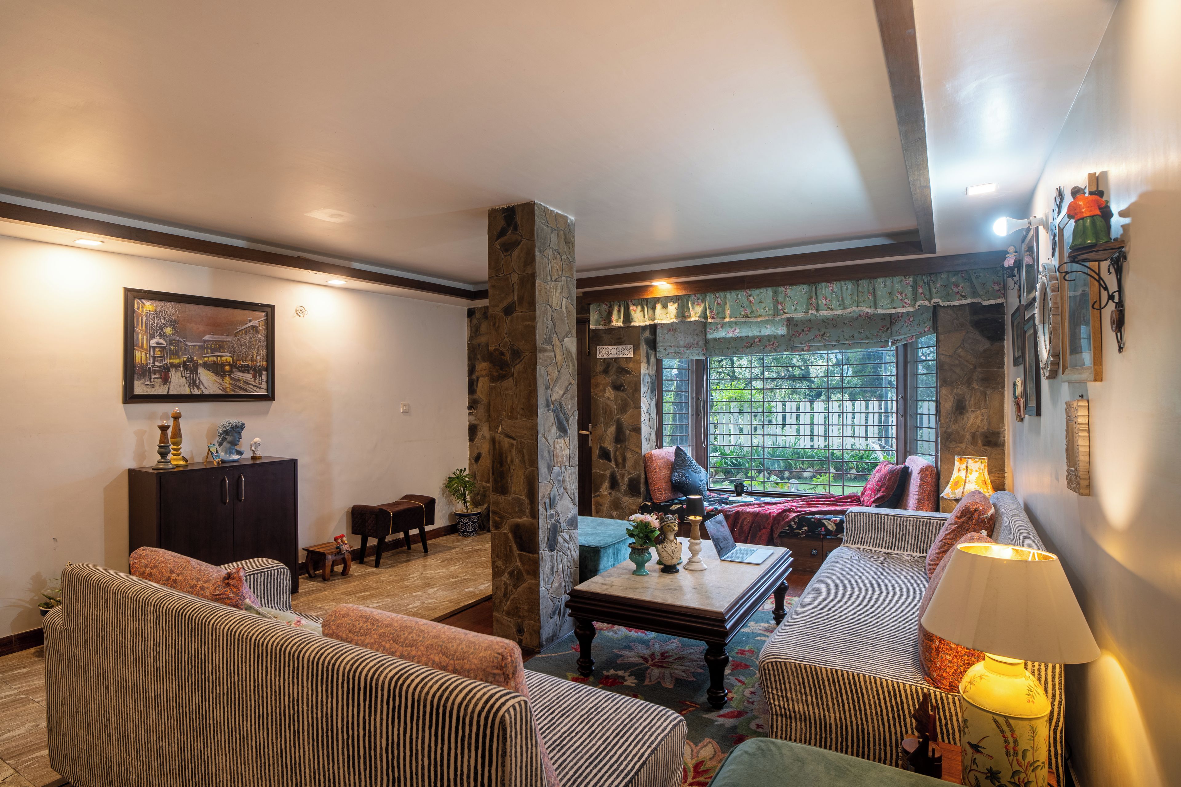 A cozy living room with striped sofas, a coffee table, and a fireplace.