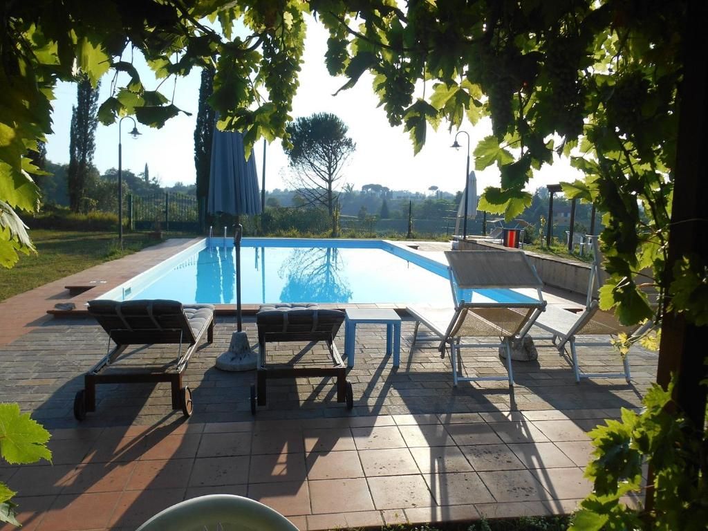 A swimming pool with lounge chairs and a pergola structure.