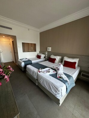 A hotel room with two beds, a bedside table, a mirror, and a door. - Tanfous Beach & Aquapark (Hammamet)