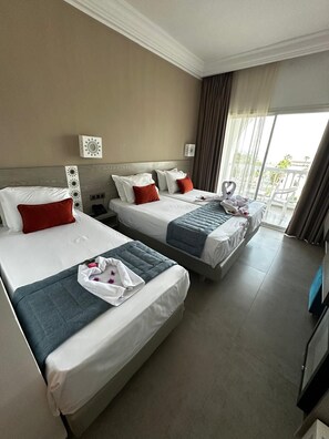 A hotel room with two beds, a large window, and a balcony. - Tanfous Beach & Aquapark (Hammamet)