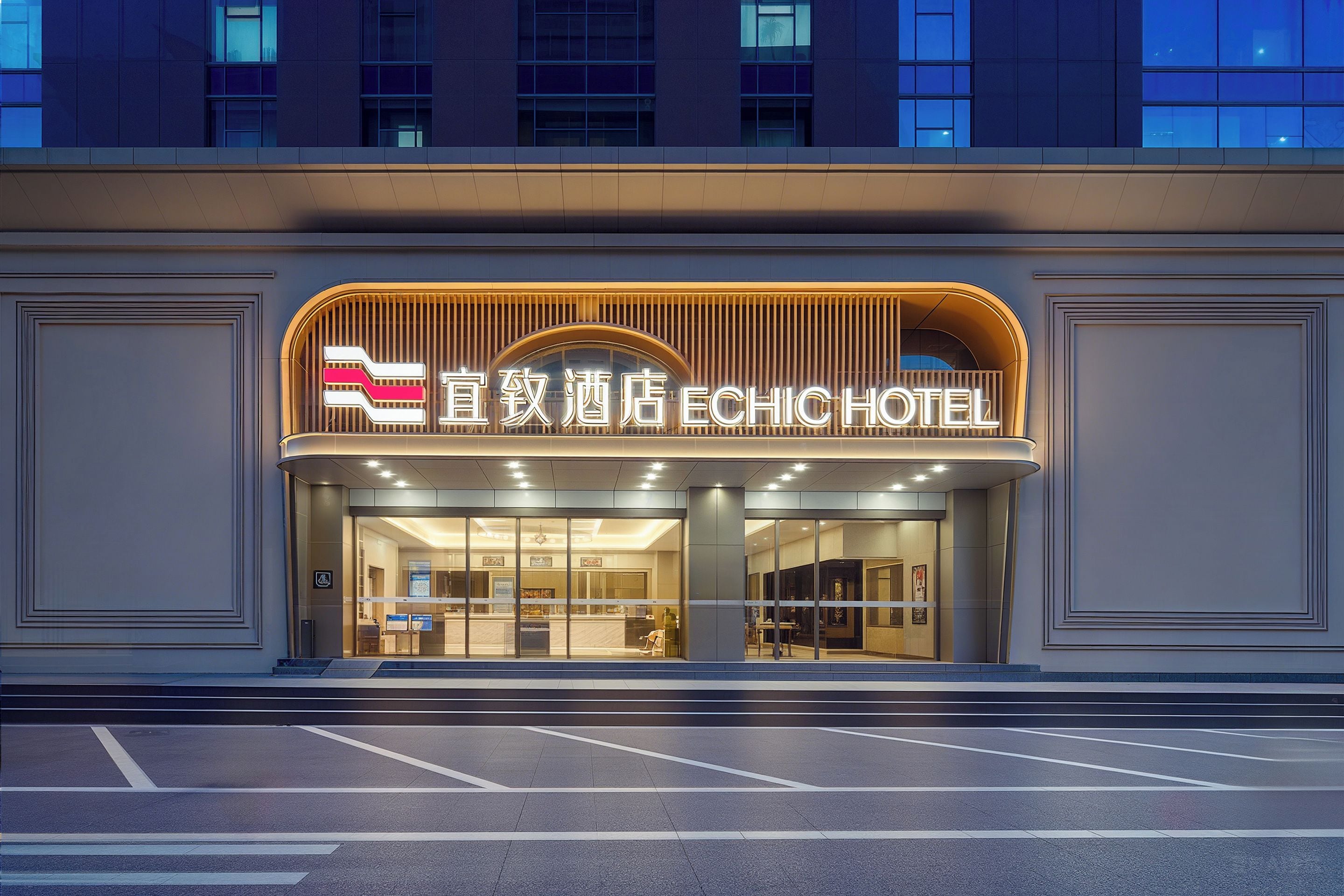 Entrada de hotel con diseño moderno, destacada por un cartel llamativo y fachada de vidrio.