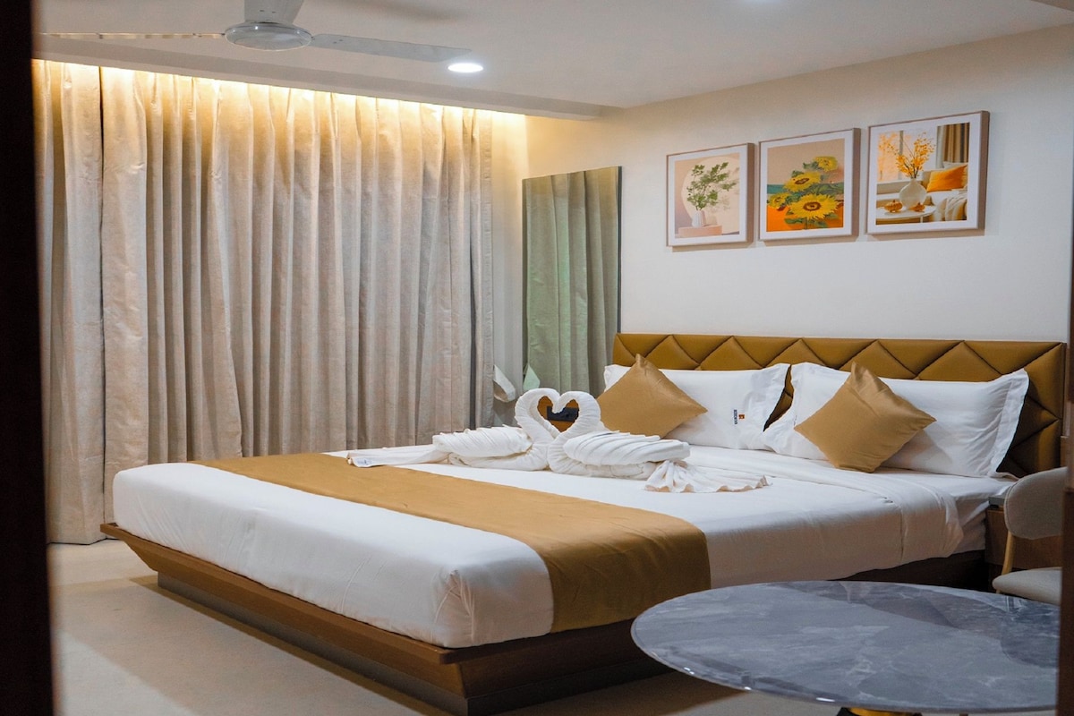 Una habitación de hotel con una cama, una mesa redonda y un ventilador de techo.