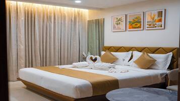 Una habitación de hotel con una cama, una mesa redonda y un ventilador de techo.