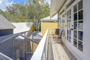 A residential property with a covered deck, a yellow house, and a white building with large windows. - 5 Mi to UF! Luxury 2-Unit Combo w/ Hot Tub (Gainesville)