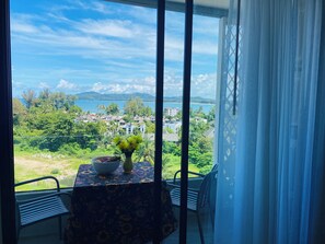 Ein Balkon mit Tisch, Stühlen und einem Blumenstrauß.