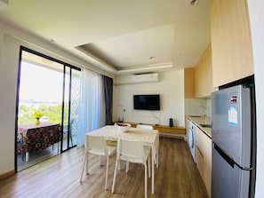 Eine moderne Küche mit einem eingebauten Samsung-Kühlschrank, einem Flachbildfernseher und einem Essbereich mit Tisch und Stühlen.