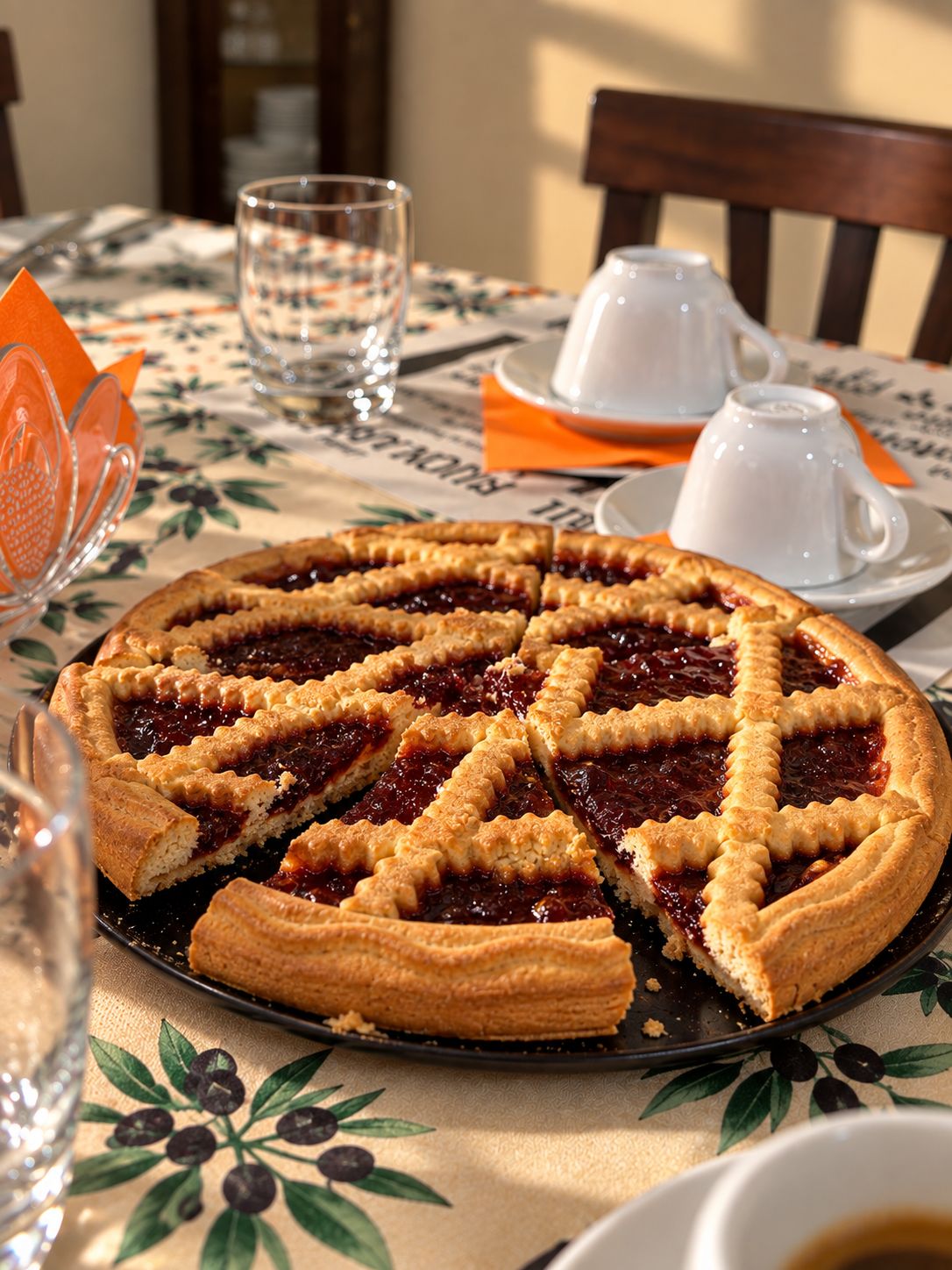 A pie with a lattice crust on a table with a floral tablecloth.