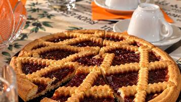 A pie with a lattice crust on a table with a floral tablecloth.