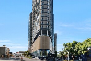 Ein modernes Hochhaus mit einer geschwungenen Fassade und einem markanten Glaseingang.