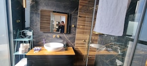 A modern bathroom with a wooden vanity, two sinks, a large mirror, and a glass shower enclosure. - JTower Royal Suites & Penthouse (Jerusalem)