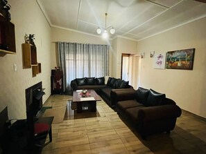 A living room with a sofa set, a coffee table, and a television.