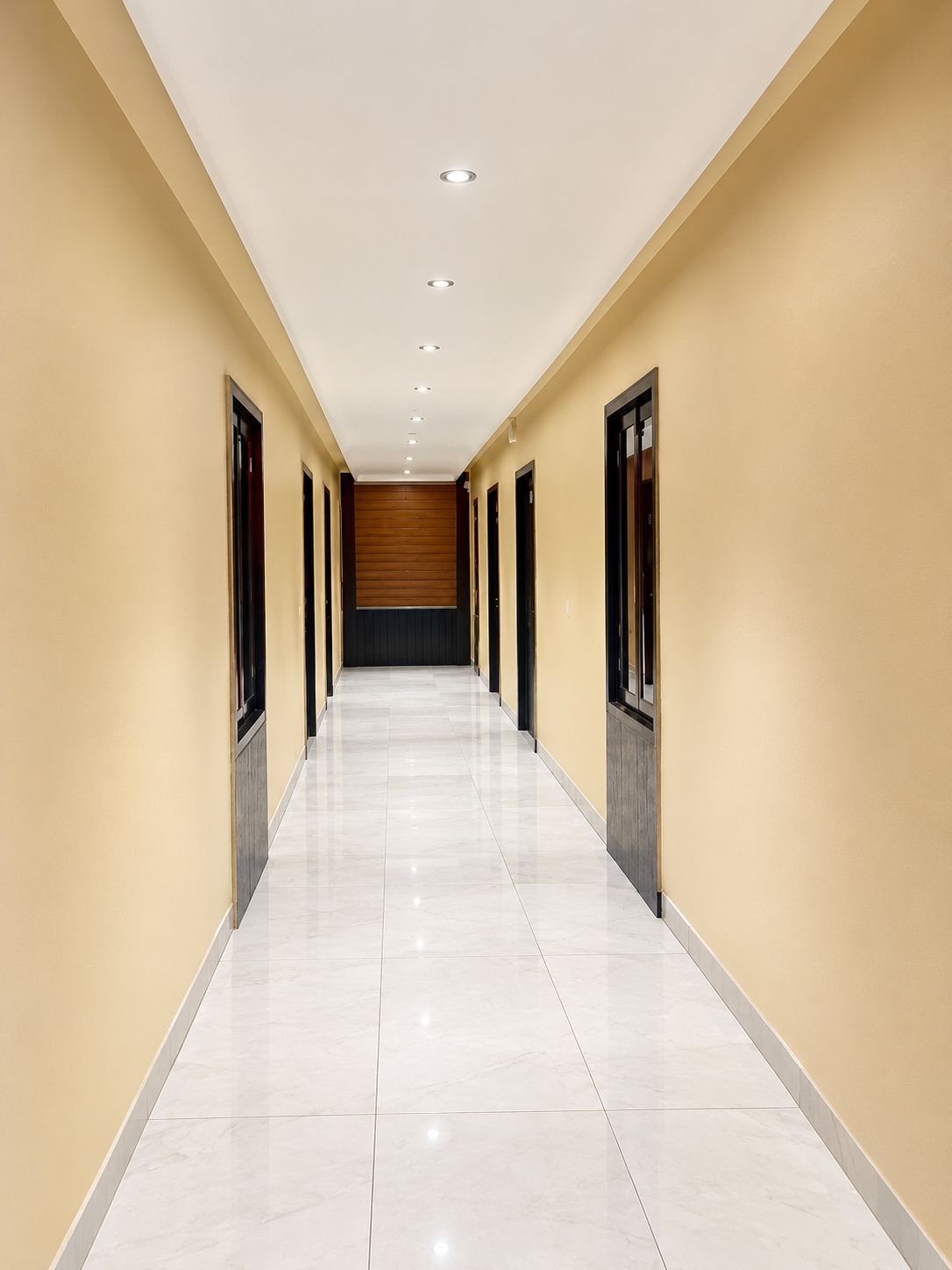 A long, narrow hallway with a tiled floor and beige walls.
