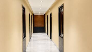 A long, narrow hallway with a tiled floor and beige walls.