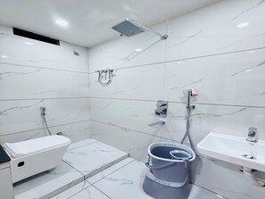 Une salle de bain moderne équipée de toilettes, d’un lavabo et d’une douche.