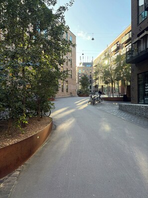 A street with buildings, trees, and a bicycle. - Two-storey flat by Carlsberg's garden (København)