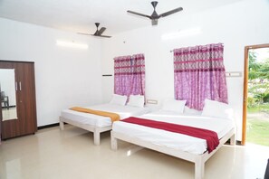 A hotel room with two beds, a ceiling fan, and a view of the outdoors.