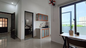 A modern apartment with a kitchen, a dining area, and a balcony with a view.