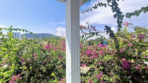 A garden with flowering plants and a white structure.