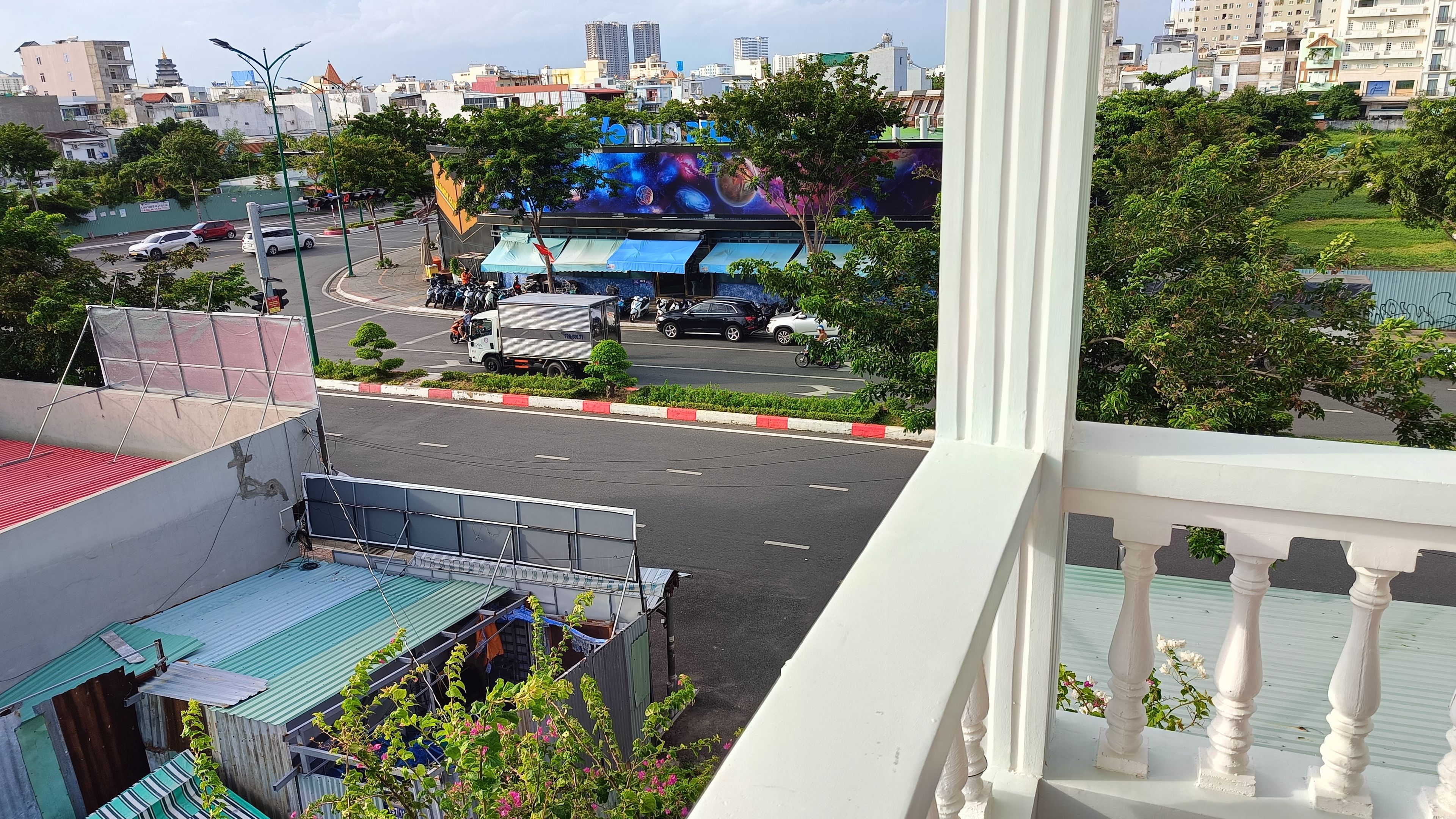 A cityscape with a view of a road, buildings, and a billboard.