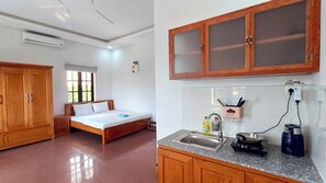 A bedroom with a bed, wardrobe, and window. The room has a tiled floor and a ceiling with an air conditioner.