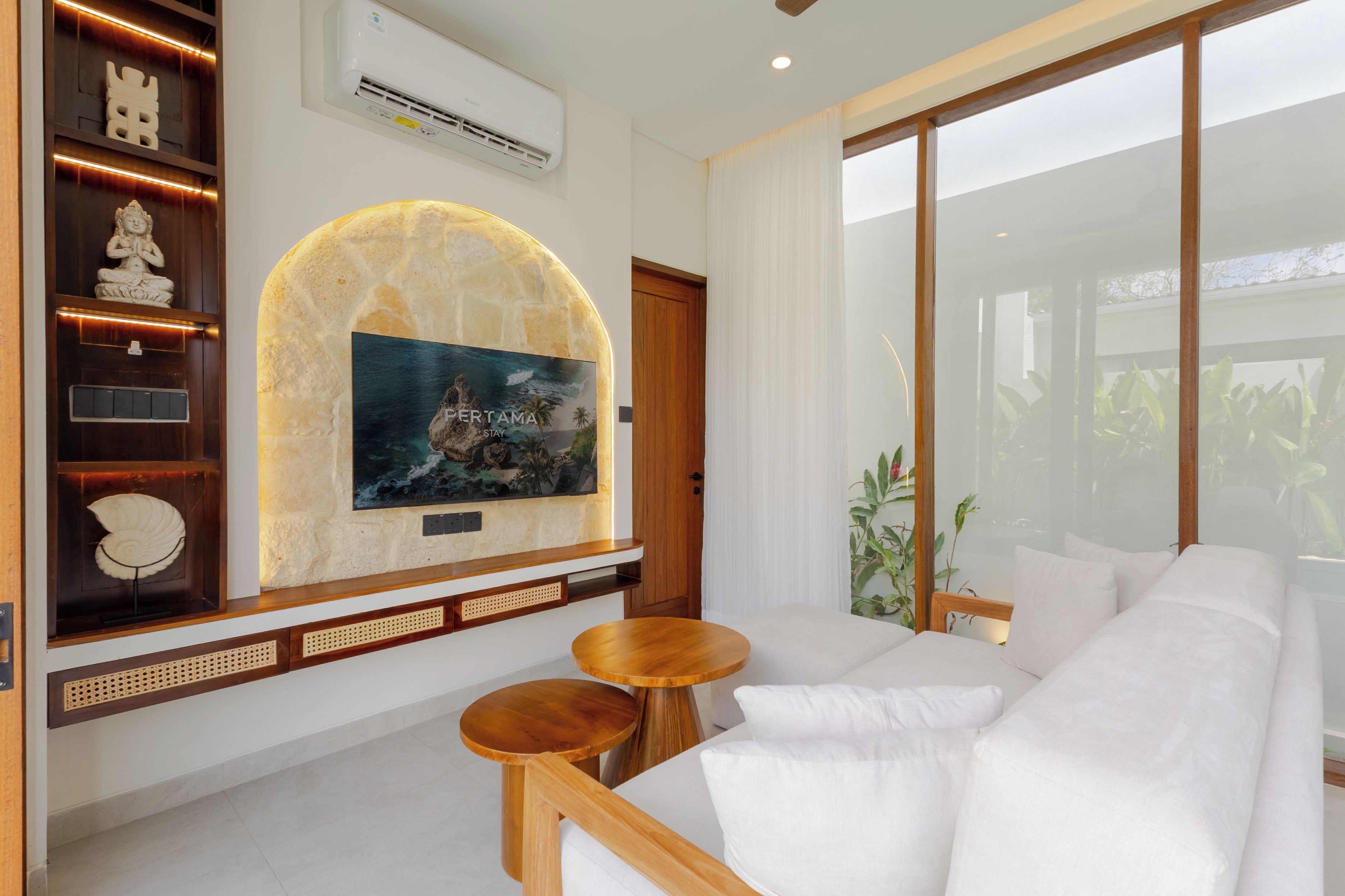 Una sala de estar moderna con una pared de piedra, una obra de arte colgada, un sofá y una mesa de centro de madera.