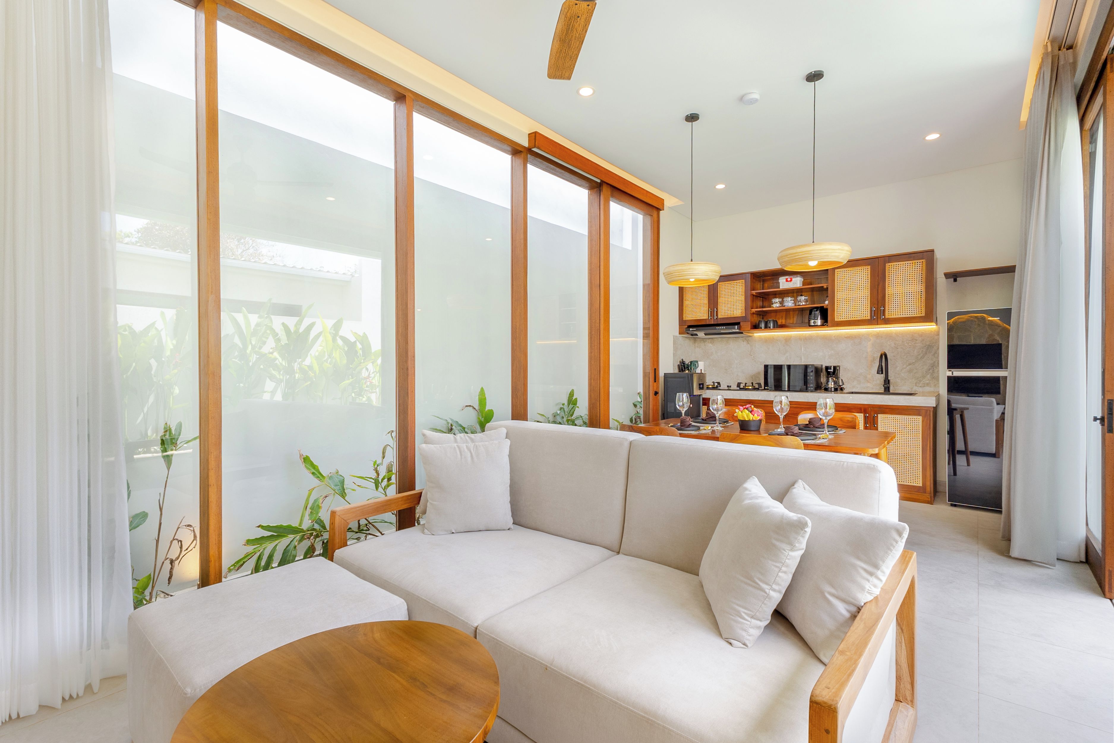 Una sala moderna con un sofá, una mesa de centro y vista a la cocina.