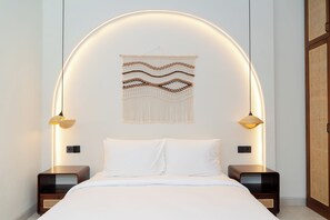 Een moderne slaapkamer met een bed, twee nachtkastjes, een wandlamp en een decoratief wandobject.