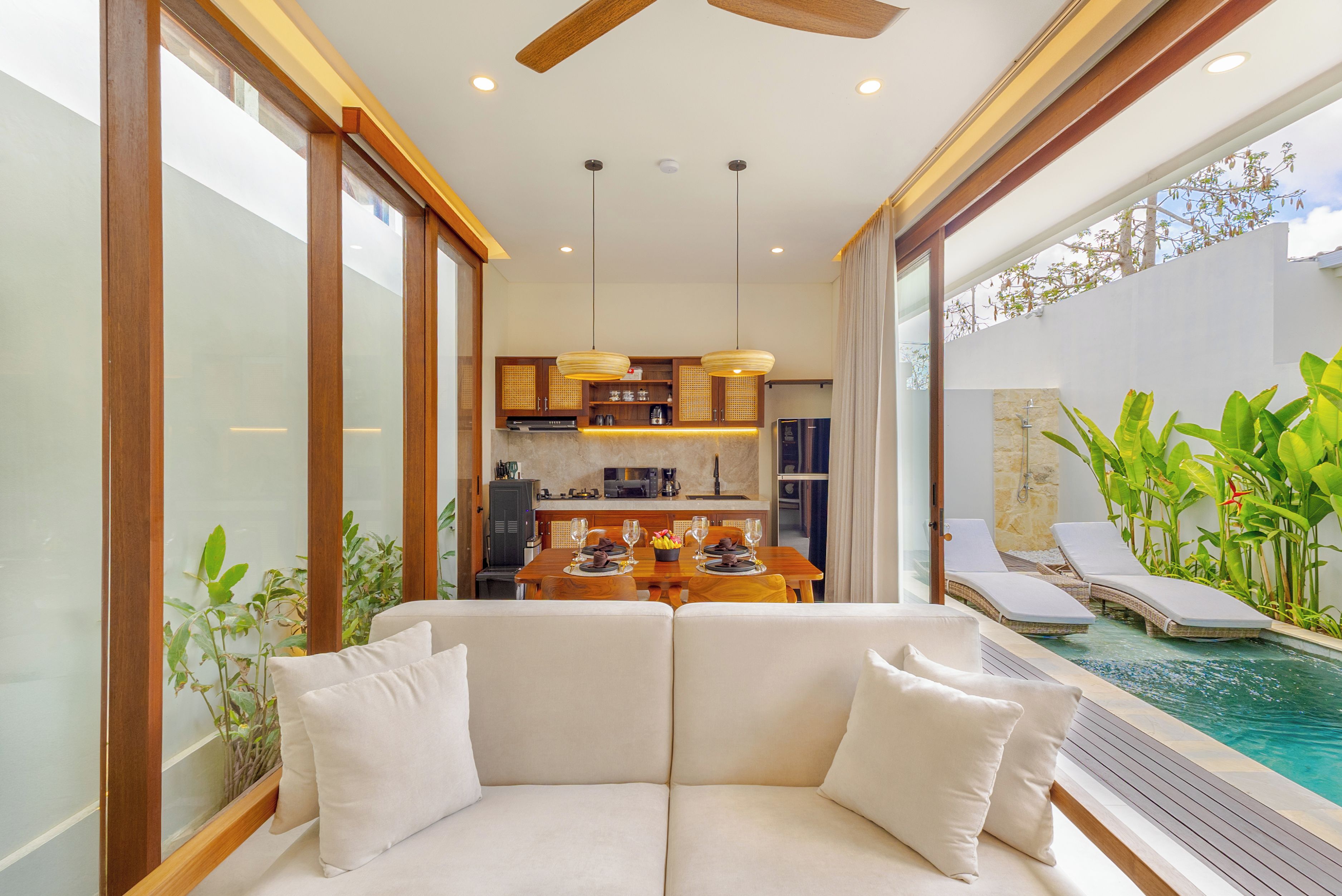 Un interior moderno con comedor, cocina y zona de estar junto a la piscina.