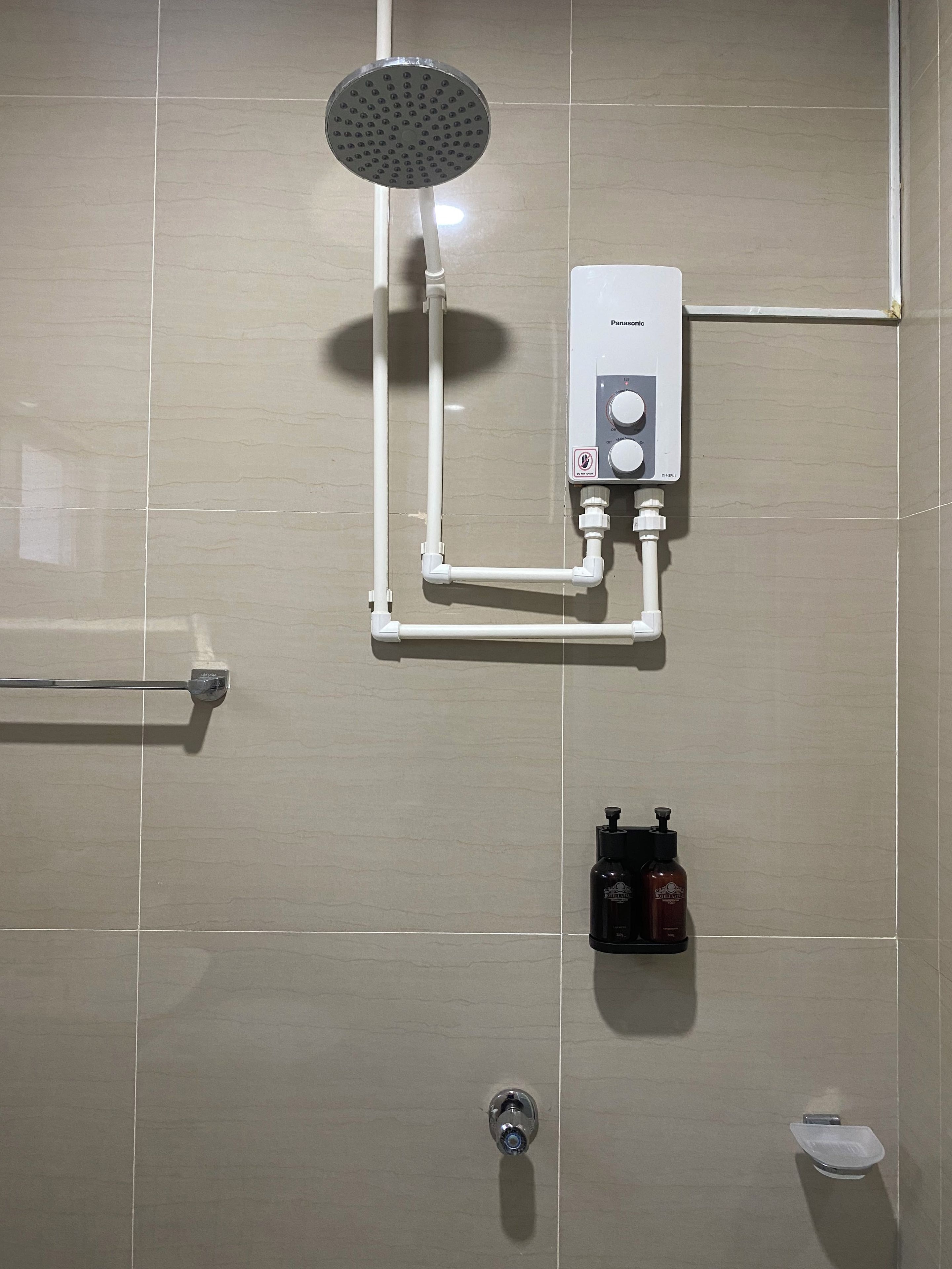 A bathroom with a shower, a toilet, and a towel rack.