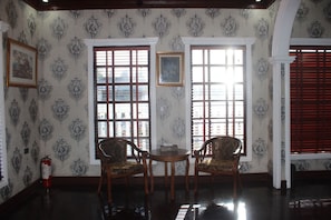 A room with two windows, a table, and two chairs. - San Franz Hotel La Perla (San Francisco)