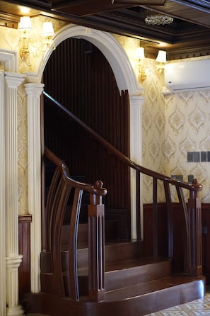 A grand staircase with ornate railings and a dark wooden door. - San Franz Hotel La Perla (San Francisco)