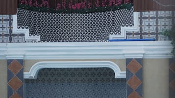 A swimming pool with a tiled edge and a decorative wall with a geometric pattern.