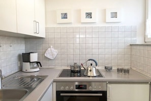 A modern kitchen with a built-in stove, oven, and coffee maker. - Holiday apartment with 1 bedroom (Konstanz)