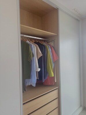 A walk-in closet with wooden shelves and hanging space for clothes. - Luxury Golf View | Pool | EV Charger | Near the Beach (Los Alcázares)